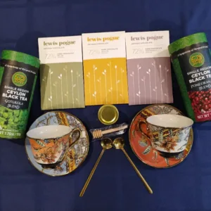 Assortment of Lewis & Pogue dark chocolate bars and two single-region Ceylon black tea tins arranged above decorative teacups on a blue tablecloth.